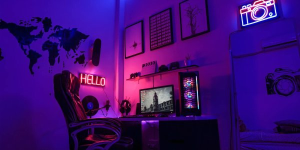 Gaming setup met scherm, toetsenbord en paarse neonverlichting