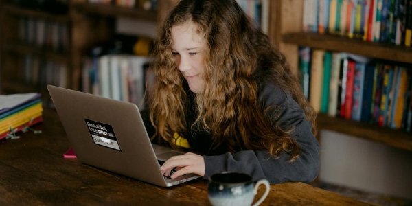Tiener aan een bureau met laptop als inspiratie voor cadeaus onder 20 euro