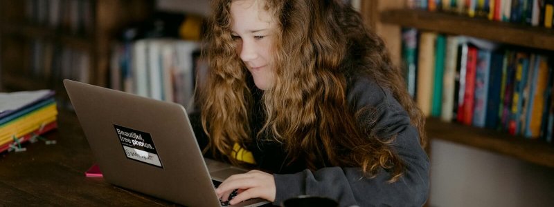 Tiener aan een bureau met laptop als inspiratie voor cadeaus onder 20 euro