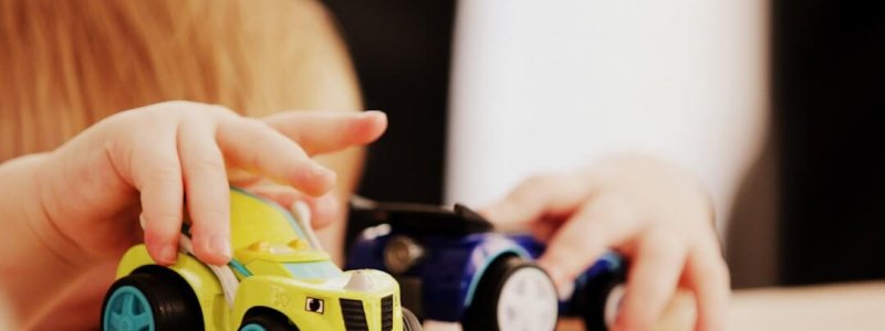 Kind speelt met speelgoedauto's als betaalbaar speelgoed cadeautje